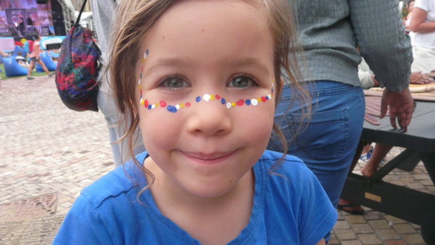 A child with her face painted.